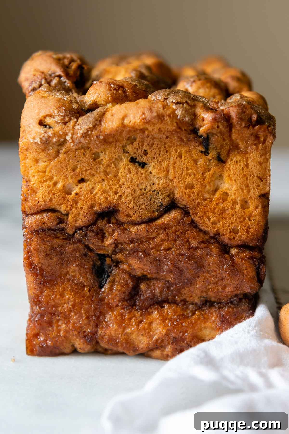 End of bread loaf on a white marble counter, showing the cinnamon swirl.
