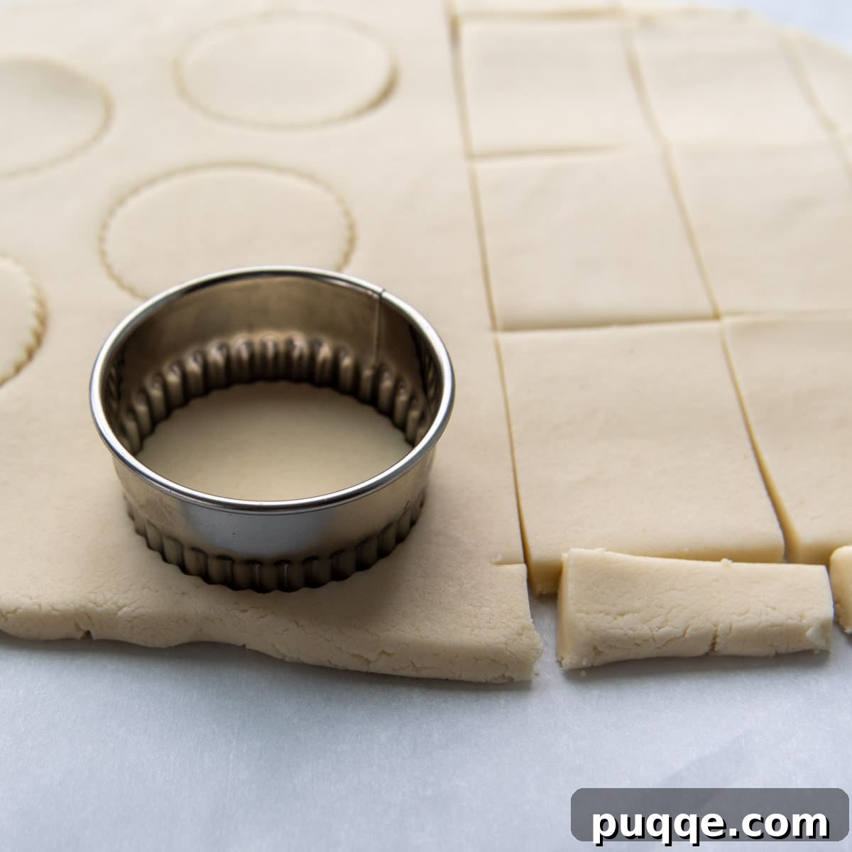 biscuit cutter cutting into rolled out dough.