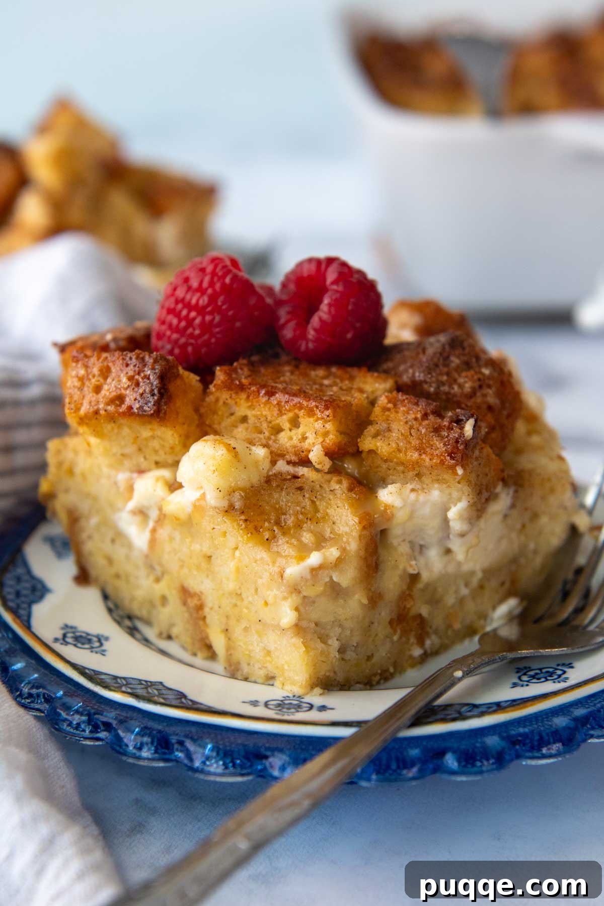 Perfect Overnight Gluten-Free French Toast Casserole 8 A slice of gluten-free French toast casserole on a blue plate, topped with fresh berries.