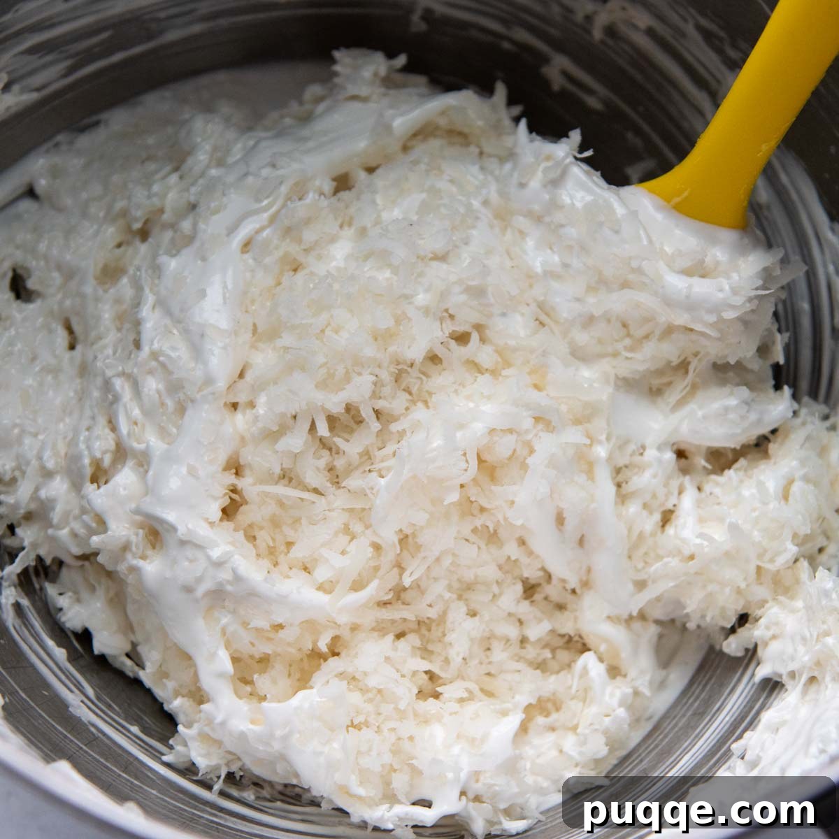 Featherlight Gluten-Free Coconut Delights 7 sweetened shredded coconut being gently stirred into the meringue mixture.