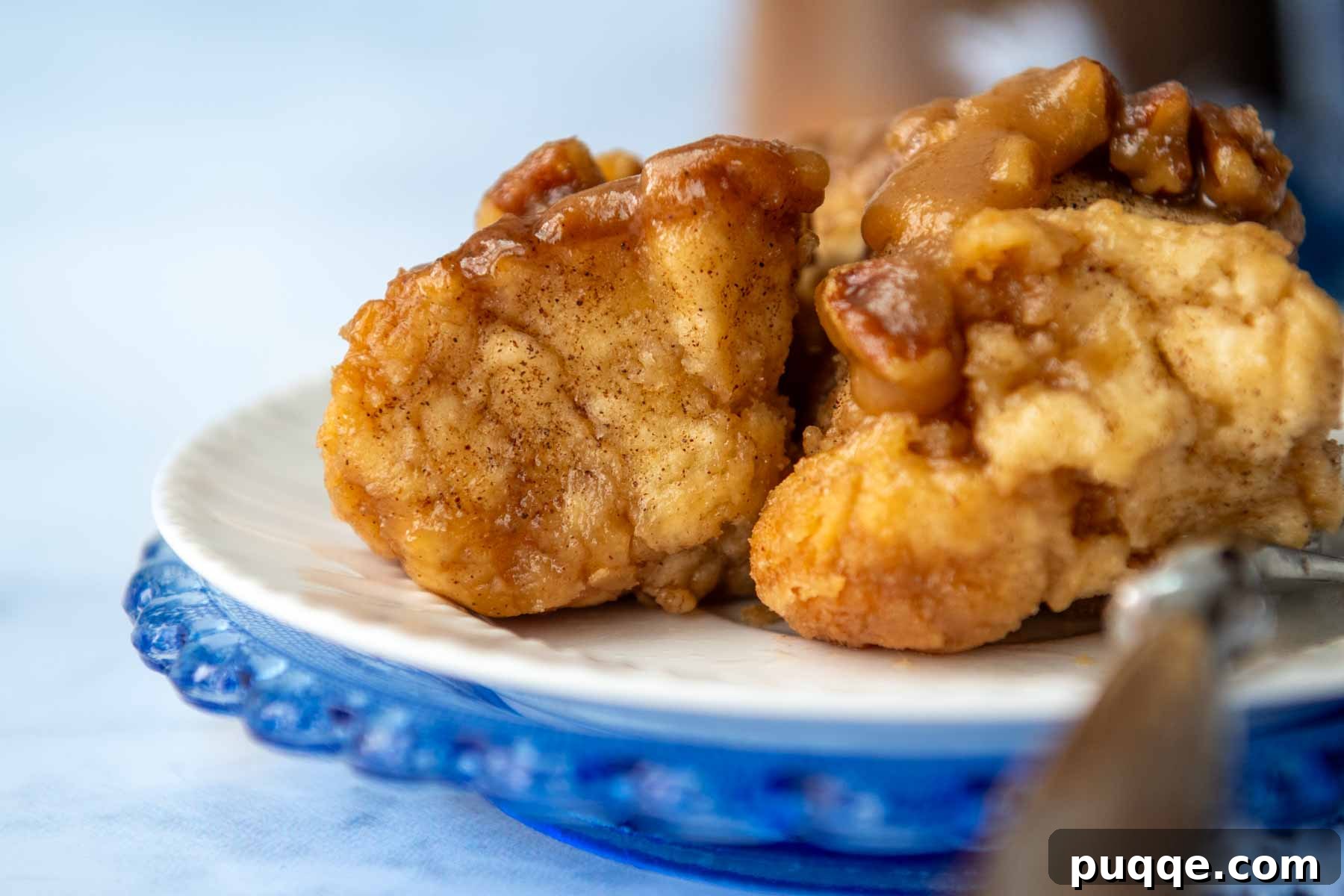 Melt-in-Your-Mouth Gluten Free Sticky Pull Apart Bread 12 A perfect serving of gluten-free monkey bread on a white plate with a fork, highlighting its inviting pull-apart texture.