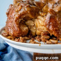 Melt-in-Your-Mouth Gluten Free Sticky Pull Apart Bread 14 Gluten-free monkey bread on a cake platter with some of it pulled out.