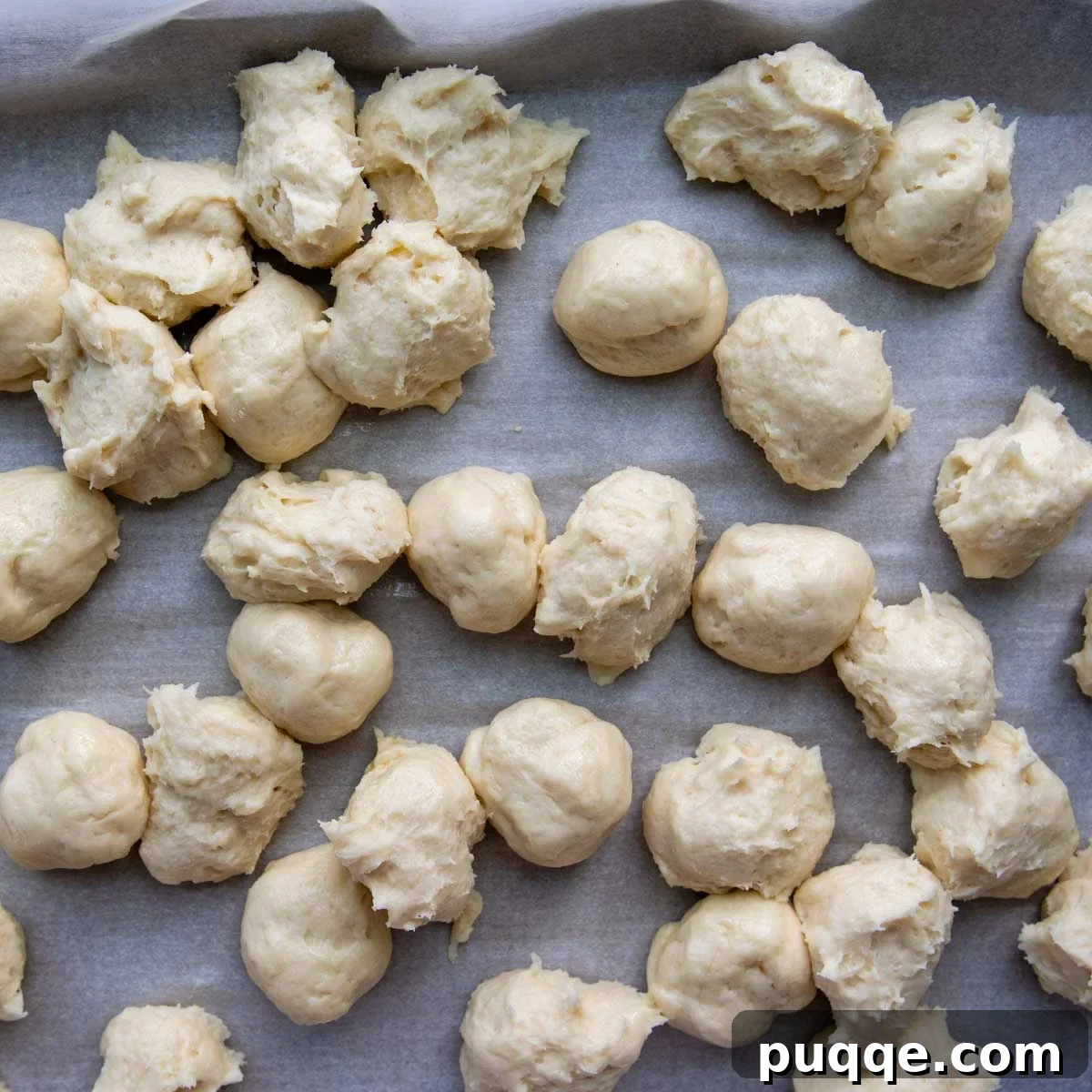 Melt-in-Your-Mouth Gluten Free Sticky Pull Apart Bread 6 Another view of portioned dough balls on parchment paper, illustrating the efficiency of the scooping method.