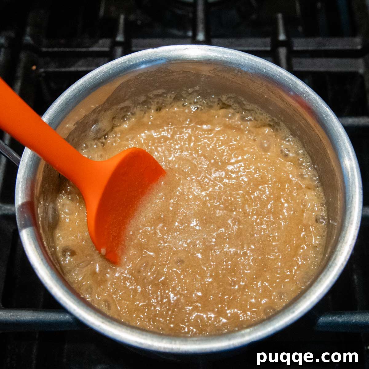Melt-in-Your-Mouth Gluten Free Sticky Pull Apart Bread 10 The caramel sauce actively boiling in a saucepan on the stovetop, indicating it's reaching the correct consistency.