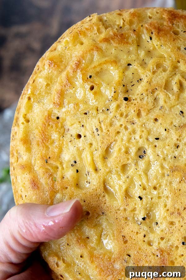 Your Go-To 5-Ingredient Socca Flatbread 4 a hand holding up a farinata flatbread up close