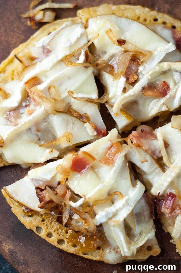 Your Go-To 5-Ingredient Socca Flatbread 5 an overhead shot of socca pizza with bacon, brie, and pear on top