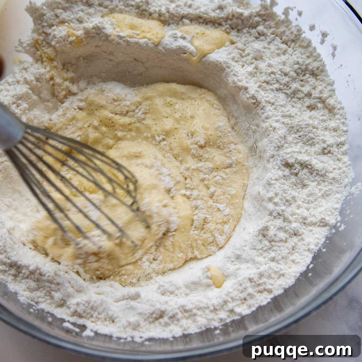 Effortless Homemade Gluten-Free Manicotti with Tender Crepe Shells 3 the crepe batter being whisked in a large glass bowl.