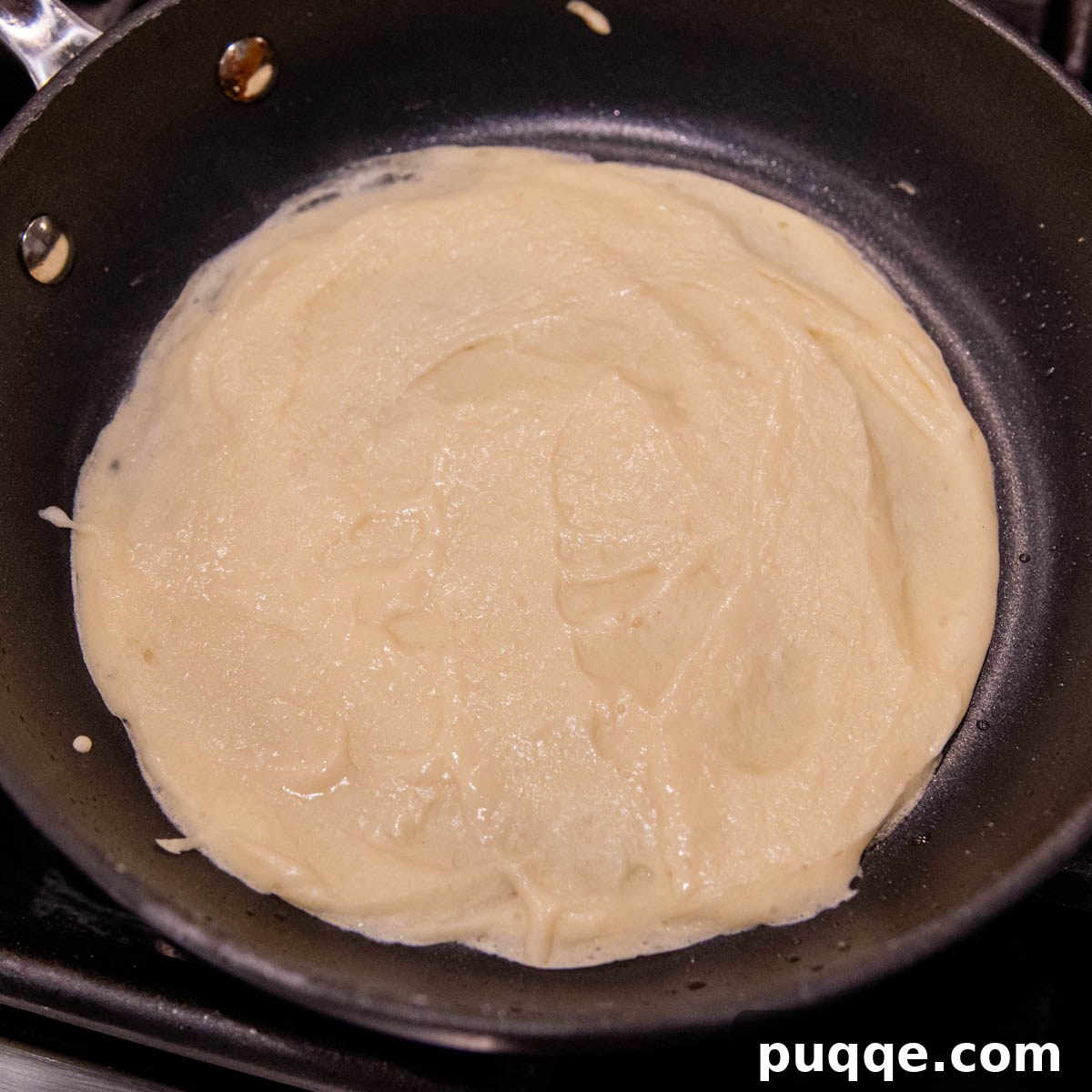 Effortless Homemade Gluten-Free Manicotti with Tender Crepe Shells 5 a golden crepe ready to flip in a hot pan.