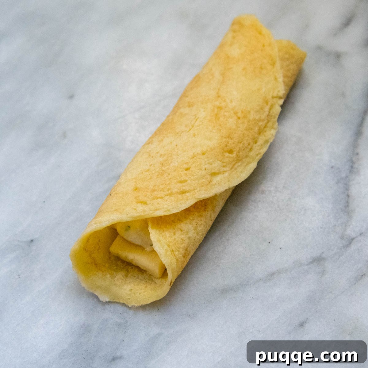 Effortless Homemade Gluten-Free Manicotti with Tender Crepe Shells 9 a manicotti shell perfectly rolled up, ready for baking.