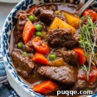 overhead shot of a bowl of beef stew with a blue napkin.