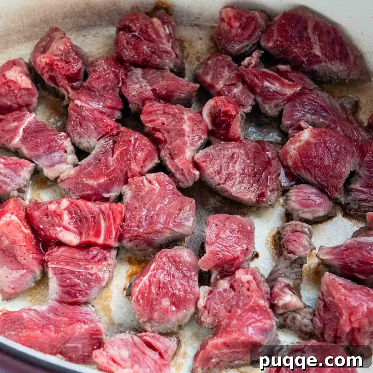 meat being seared in a dutch oven.
