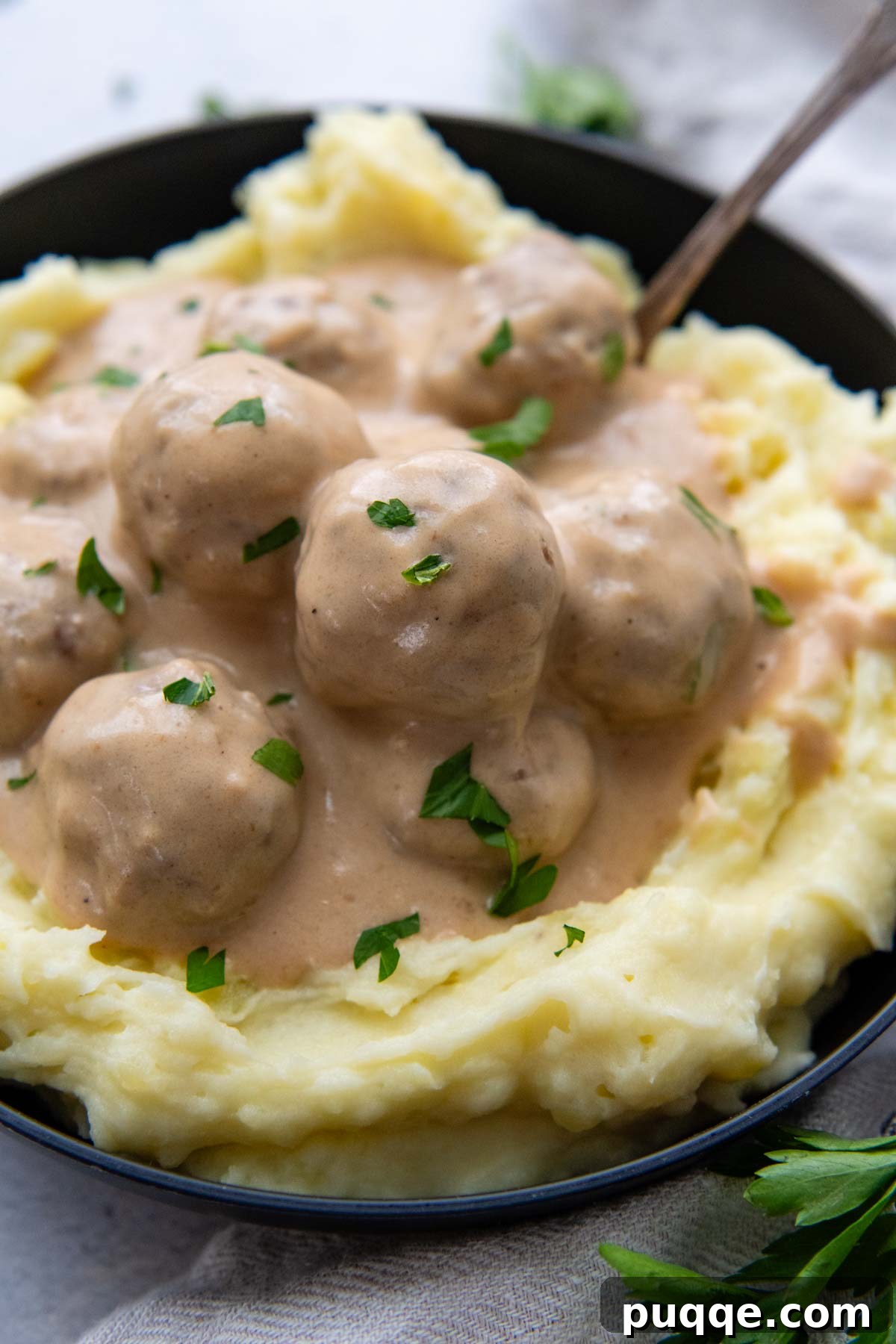 Effortless Oven Baked Gluten-Free Swedish Meatballs 8 A beautifully plated serving of gluten-free Swedish meatballs over mashed potatoes, garnished for presentation.