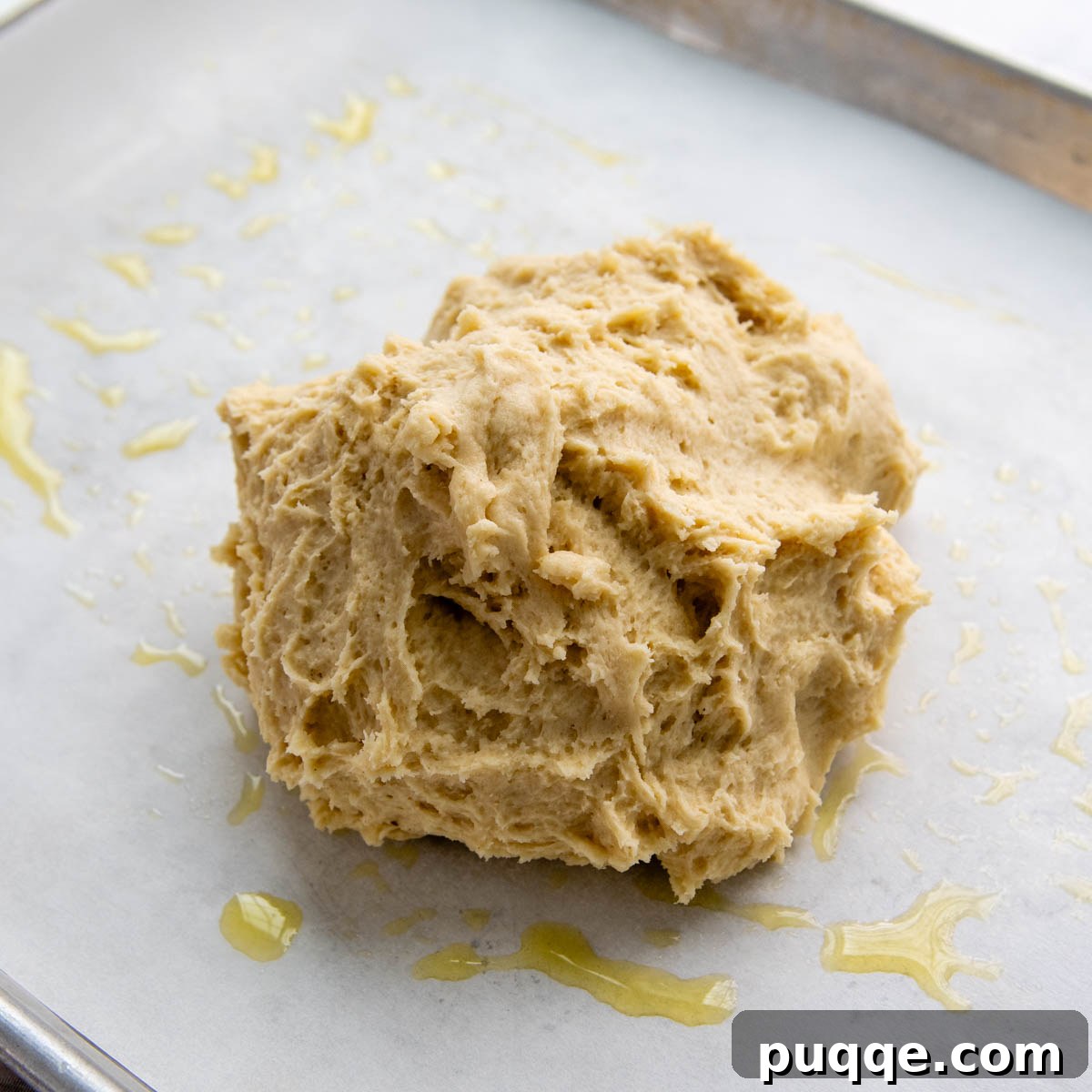 Effortless Homemade Gluten-Free Italian Bread 4 Gluten-free Italian bread dough loosely balled on greased parchment paper, pre-shaping.