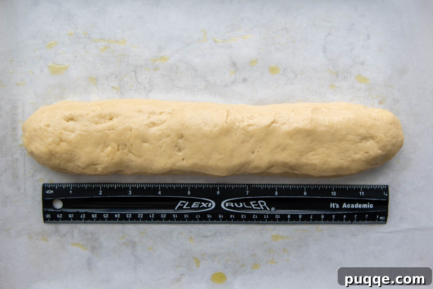 Effortless Homemade Gluten-Free Italian Bread 5 A ruler measuring the length of the shaped gluten-free Italian bread dough on parchment paper.