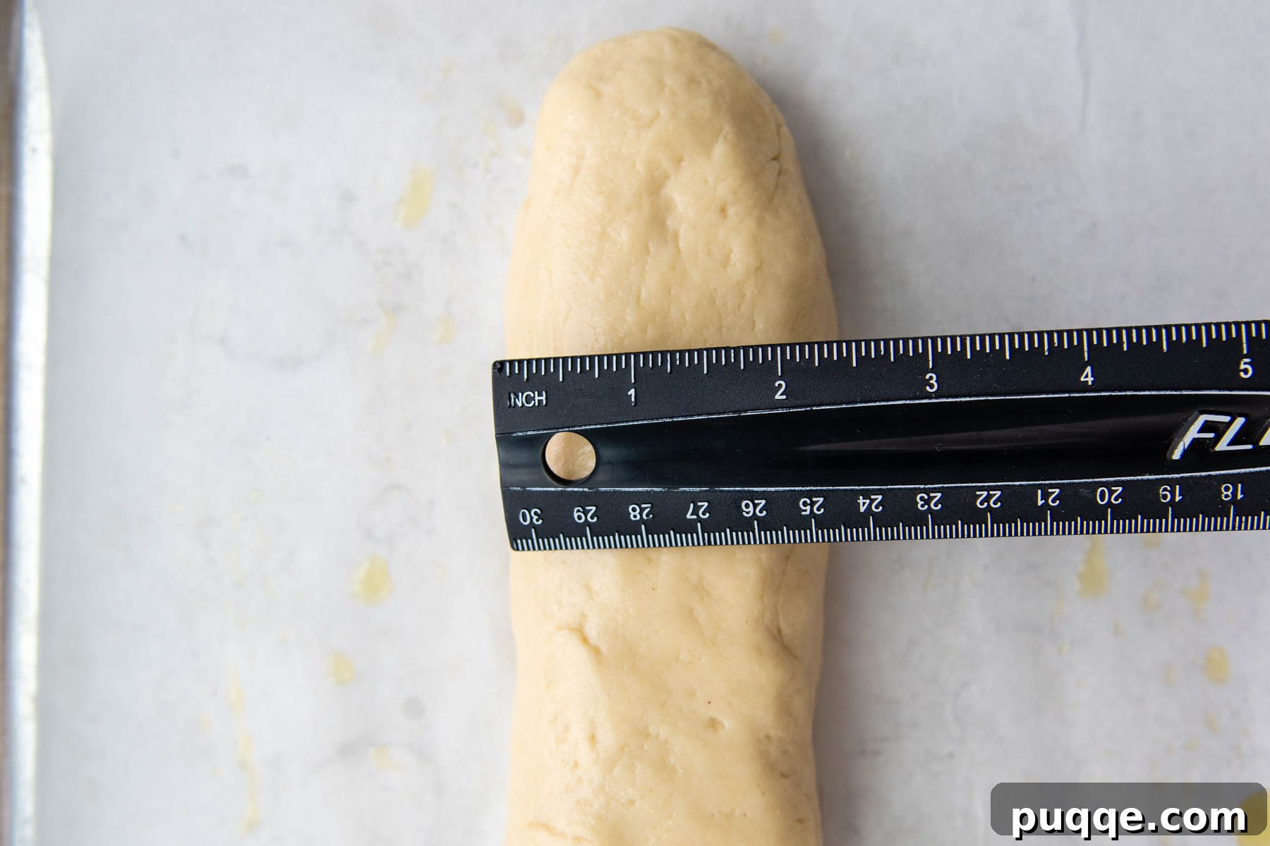 Effortless Homemade Gluten-Free Italian Bread 6 A ruler measuring the width of the shaped gluten-free Italian bread dough, demonstrating its plump form.