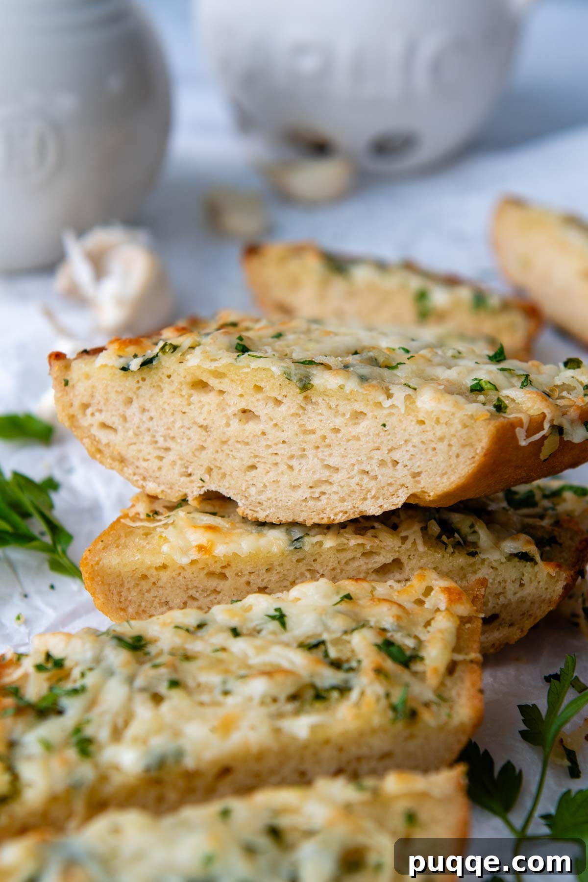 A perfectly cut slice of crispy gluten-free garlic toast, stacked invitingly on other slices, ready to be enjoyed.