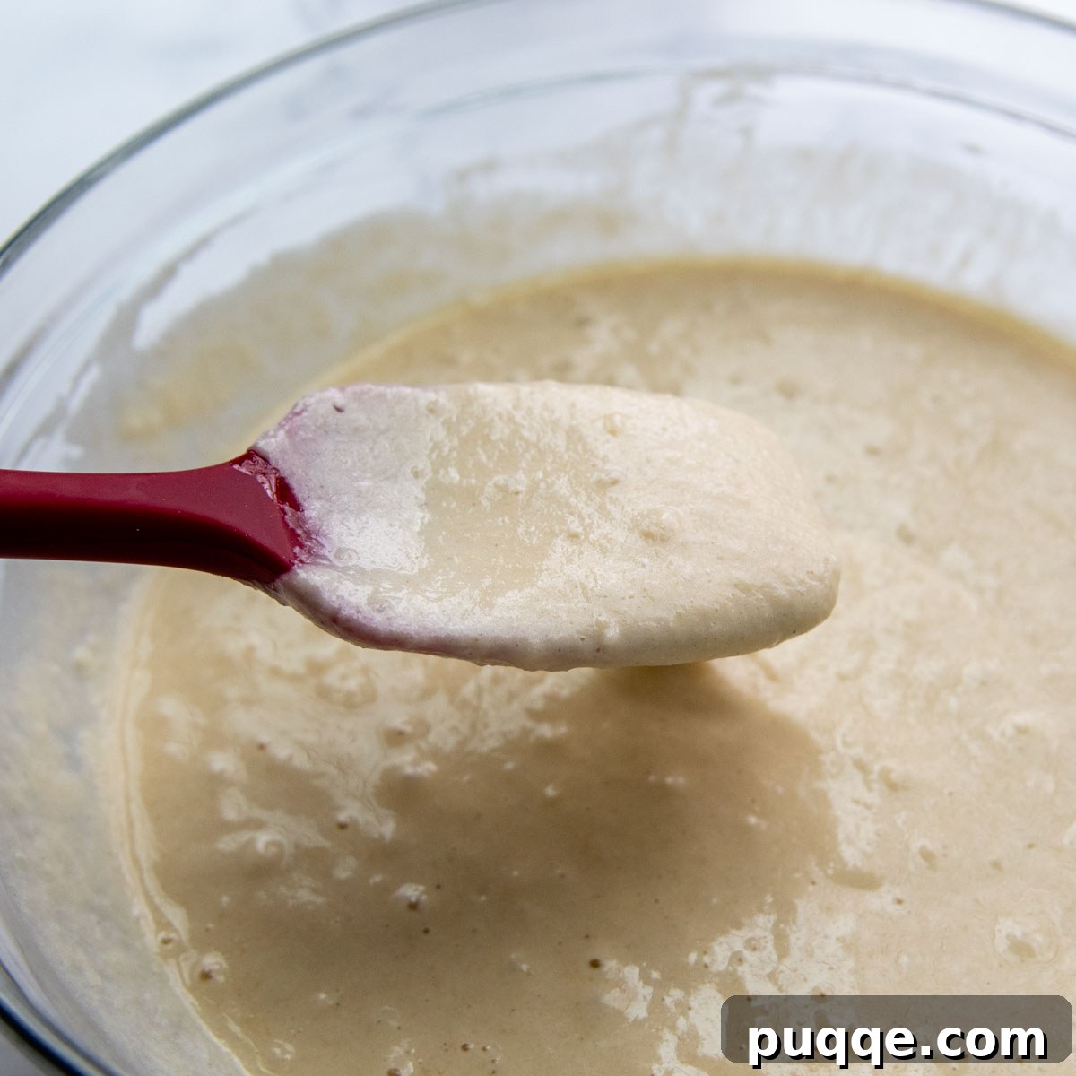 A close-up shot of a noticeably thinner, more spreadable pancake batter in a mixing bowl, achieved with the recommended gluten-free flour, ideal for light and airy pancakes.