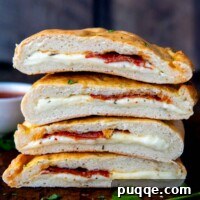 A stack of golden-brown gluten-free calzones sliced in half on top of each other.