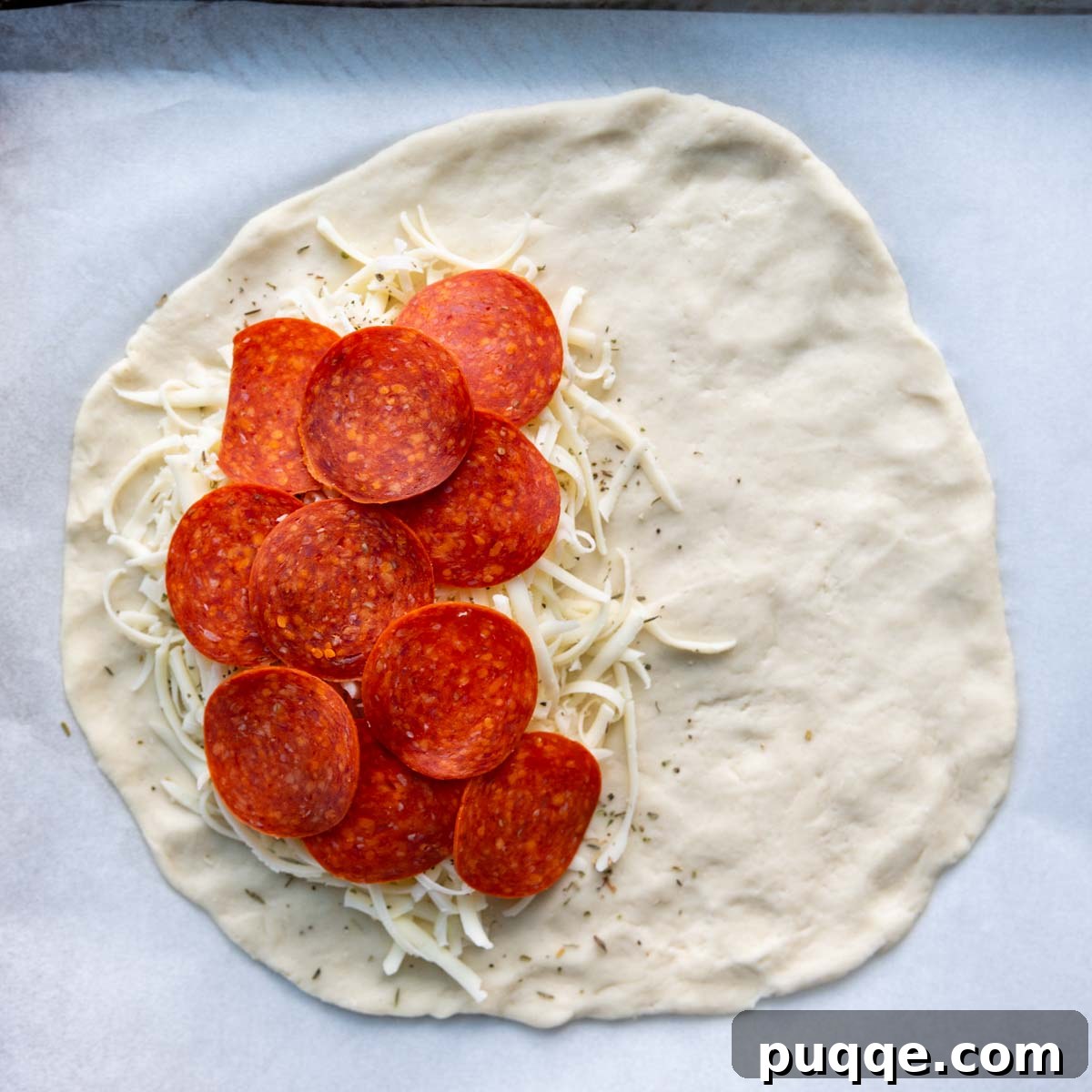 Pillowy Soft Gluten-Free Calzones 6 One half of the dough circle generously topped with grated mozzarella cheese and various pizza fillings, leaving a border for sealing.