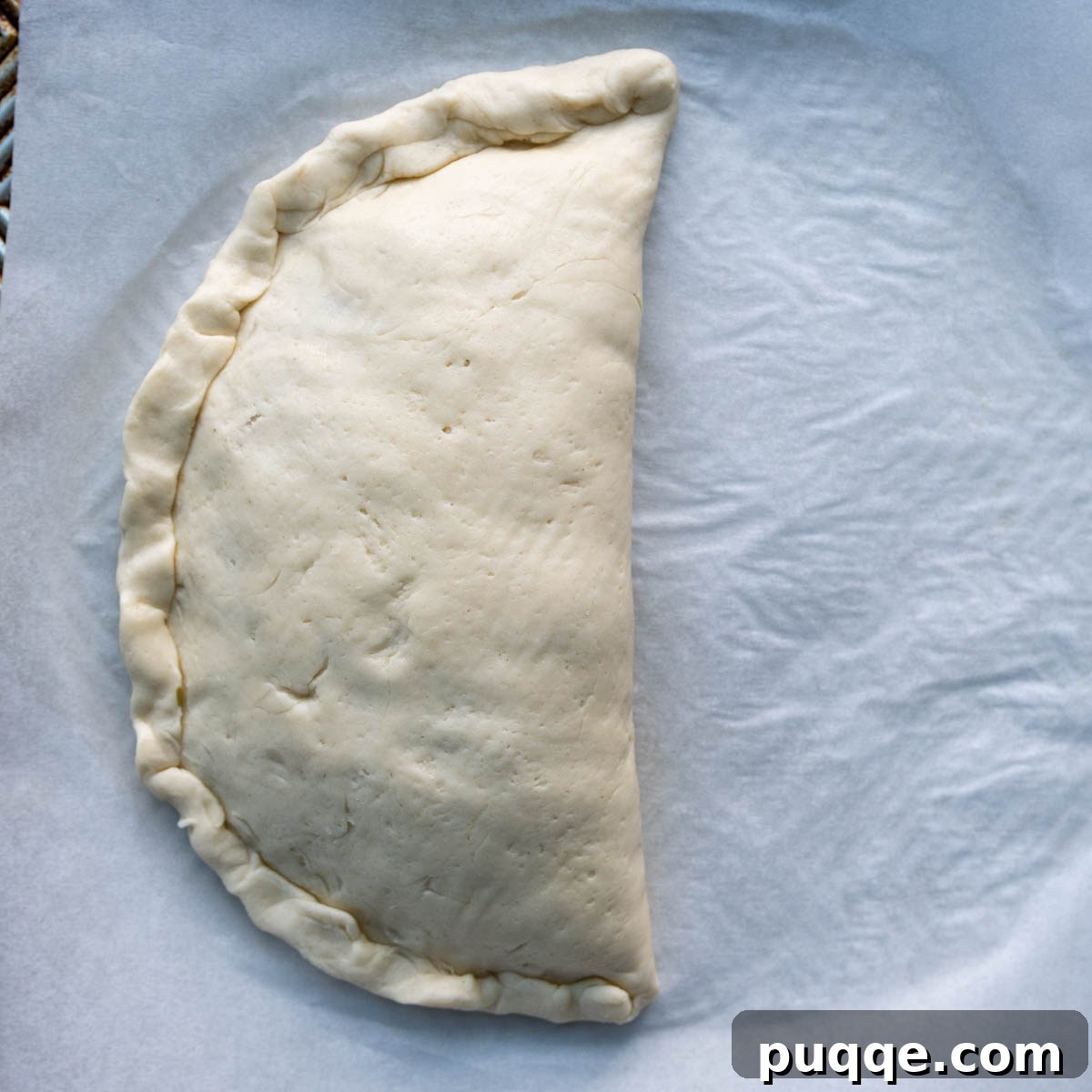 Pillowy Soft Gluten-Free Calzones 8 The pressed seam of the calzone being rolled upwards towards the main body of the calzone, reinforcing the seal.