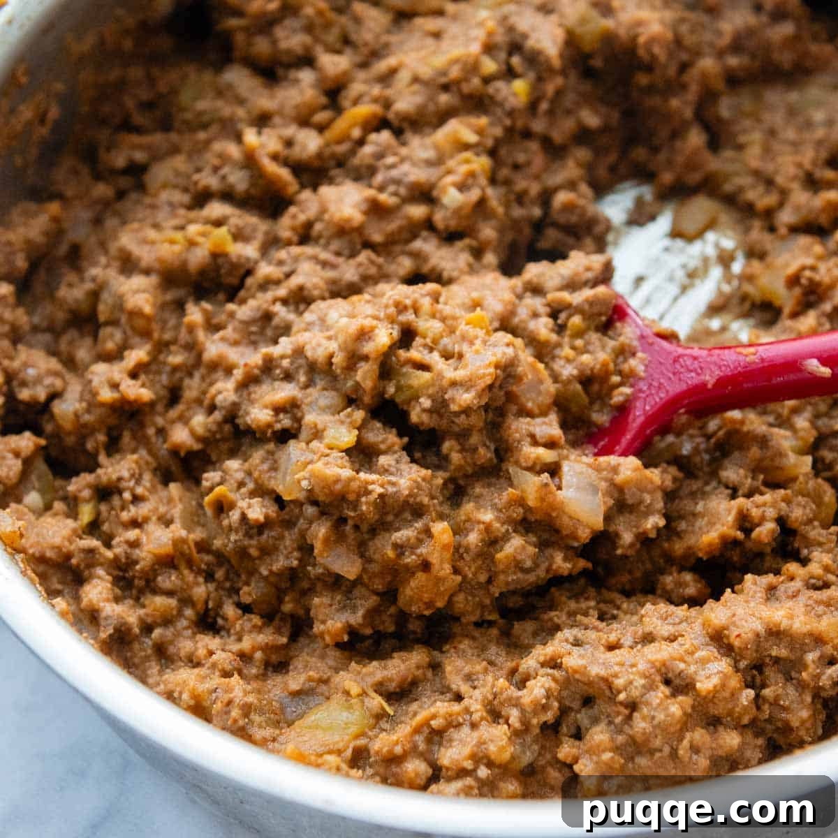 Ultimate Gluten-Free Cheesy Beef and Bean Enchiladas 4 The beef and bean filling simmering in a skillet, becoming smooth and creamy.