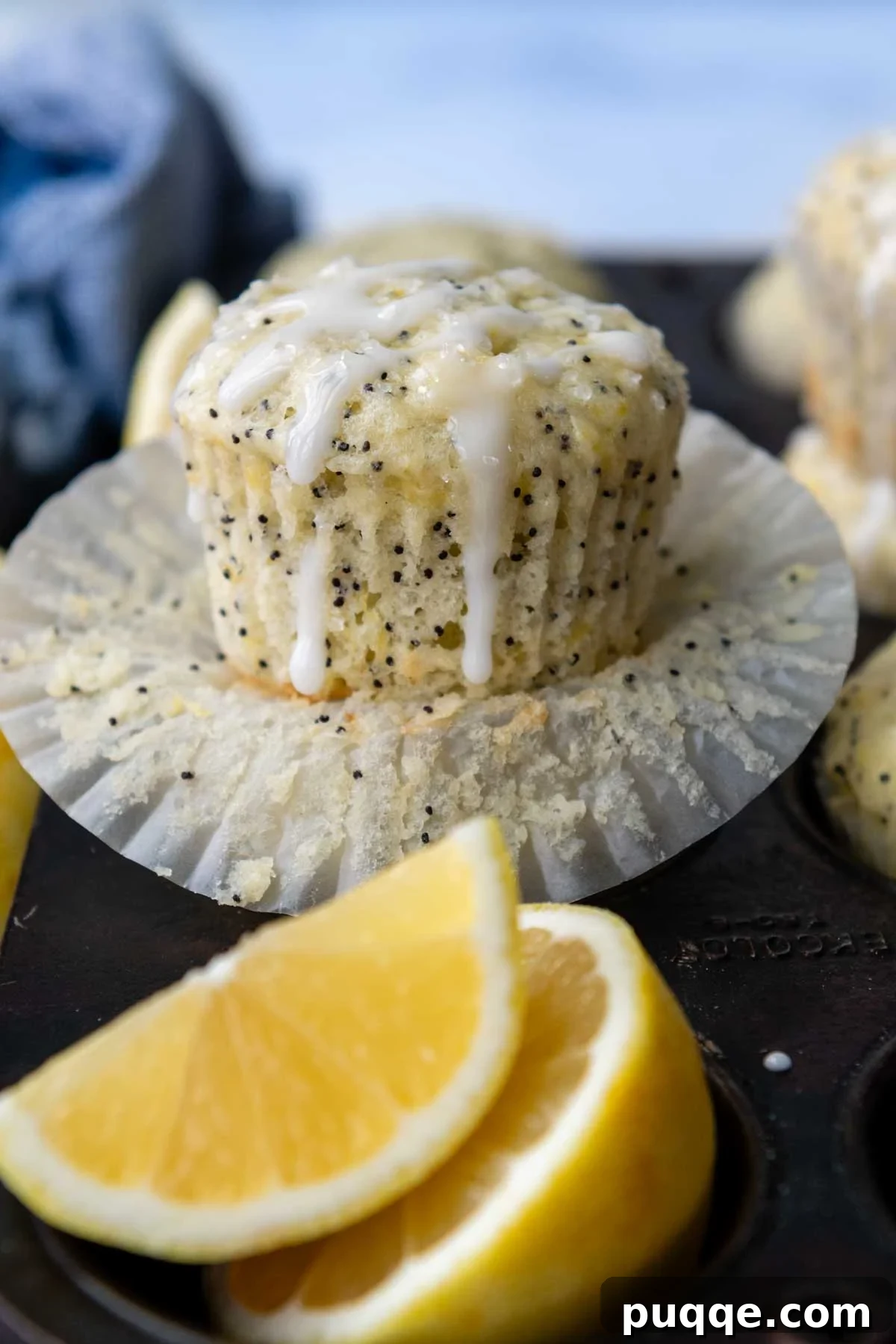 A beautifully baked gluten-free lemon poppy seed muffin with glaze, resting in its paper liner, ready to be enjoyed.