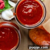 top view to 2 glass jars with sauce and a wooden spoon next to it.