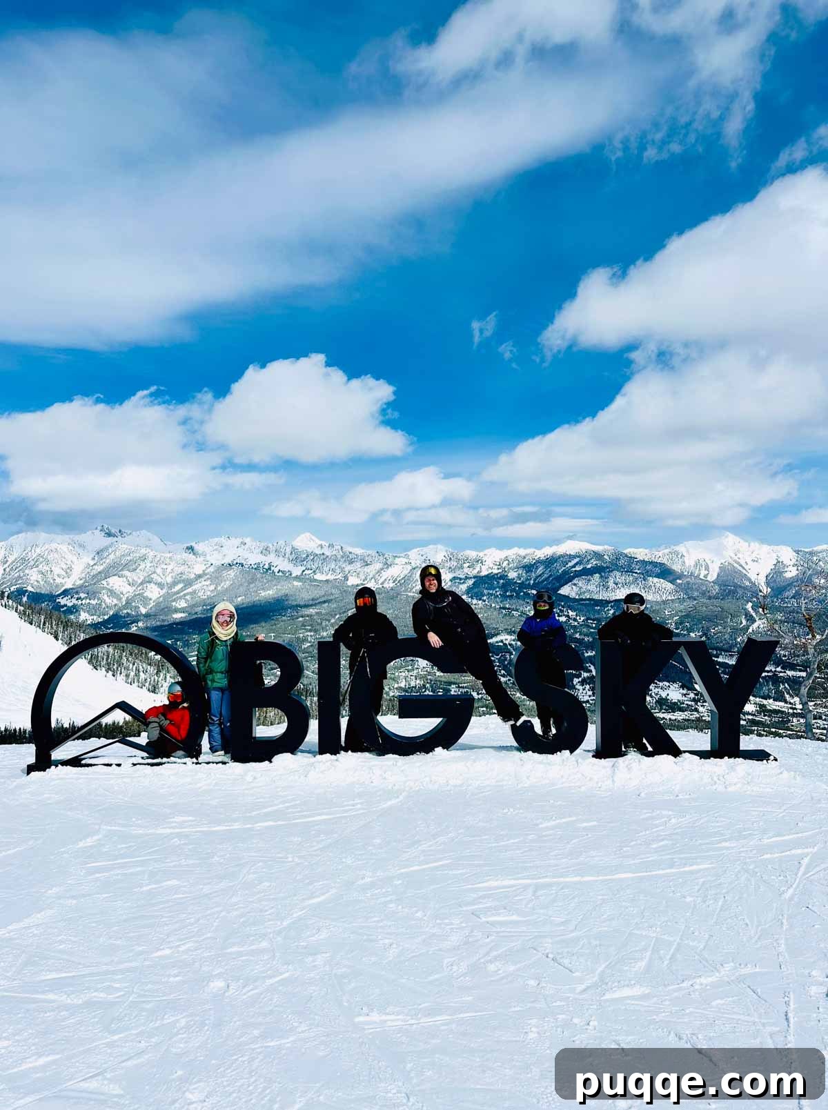Big Sky Resort: The Ultimate Family Guide 3 Family posing happily by the iconic Big Sky welcome sign, ready for a day of skiing and snowboarding.