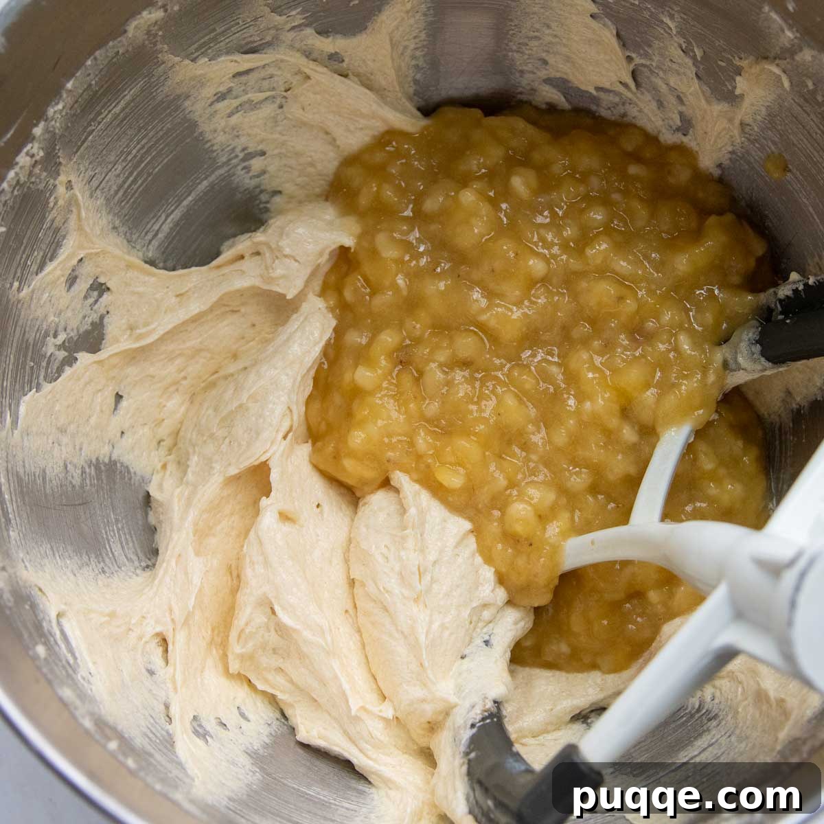 Cloud-Like Gluten-Free Banana Cake 5 Mashed ripe bananas and extracts being incorporated into the creamy batter, creating a fragrant mixture.