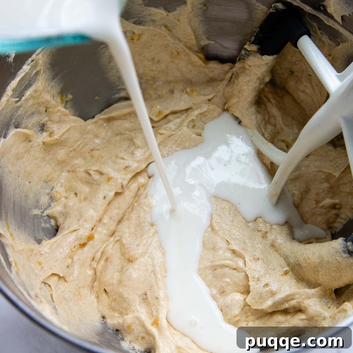 Cloud-Like Gluten-Free Banana Cake 6 Buttermilk being slowly poured into the cake batter, alternating with dry ingredients for optimal mixing.
