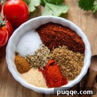 Easy DIY Gluten-Free Taco Spice Blend 5 a small white bowl with spices in it and cherry tomatoes next to it.