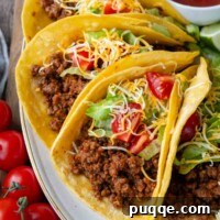 Revolutionary Gluten Free Weeknight Tacos 11 A plate of ground beef tacos on a white plate with salsa in the background.