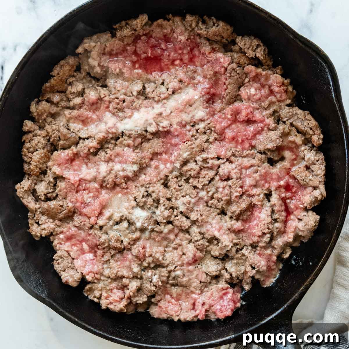 Revolutionary Gluten Free Weeknight Tacos 4 Ground beef searing in a cast iron skillet, pressed into a flat layer to achieve a deep, flavorful crust.