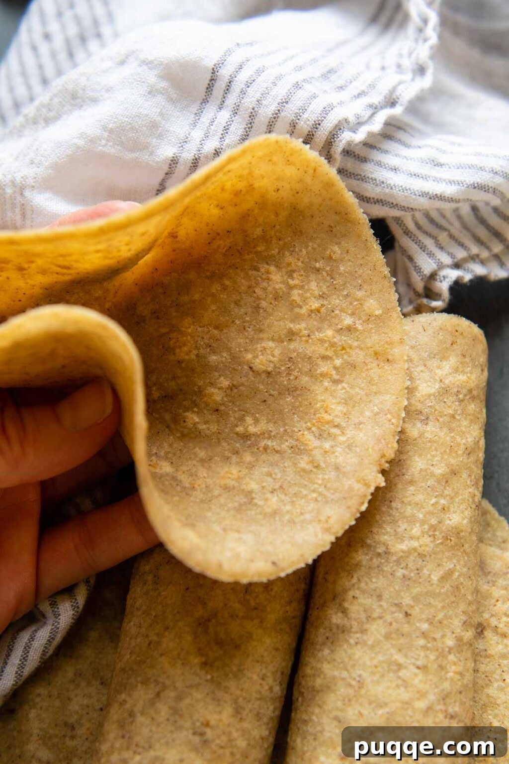 Revolutionary Gluten Free Weeknight Tacos 9 A pliable almond flour tortilla being held up, demonstrating its soft and foldable texture, perfect for low-carb tacos.