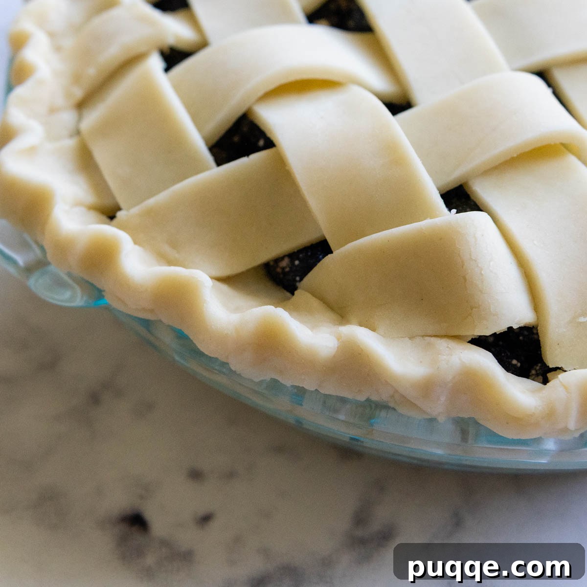 The beautifully fluted and crimped pie crust edge, showcasing the decorative finishing touch.