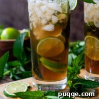 A mojito cocktail shown head-on, expertly garnished with a lime slice and fresh mint leaves, ready to be enjoyed.