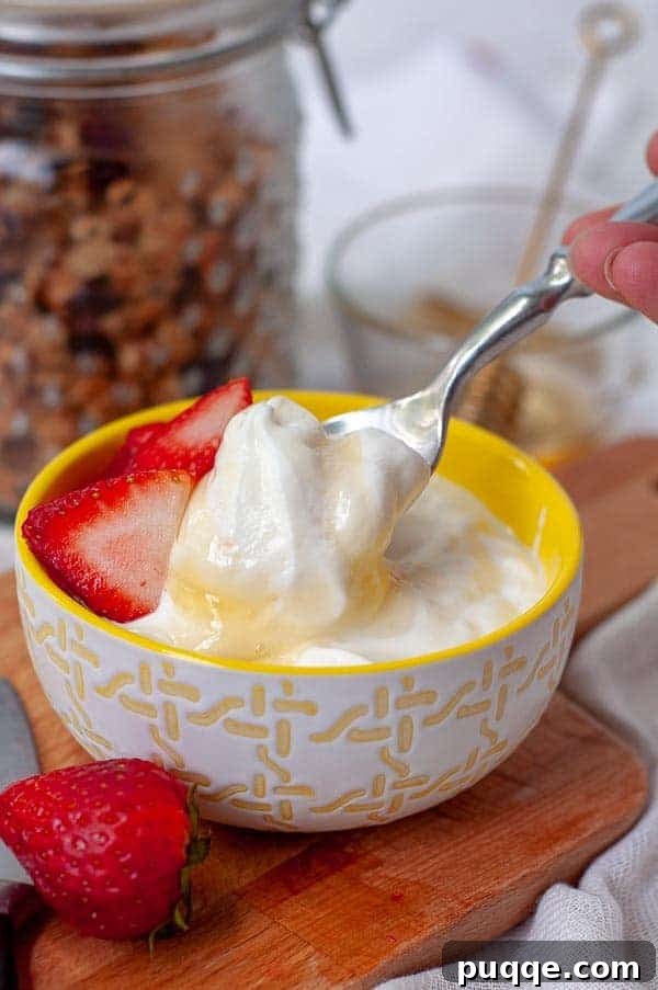 A spoon dipping into a bowl of perfectly creamy homemade Instant Pot yogurt, drizzled with golden honey.