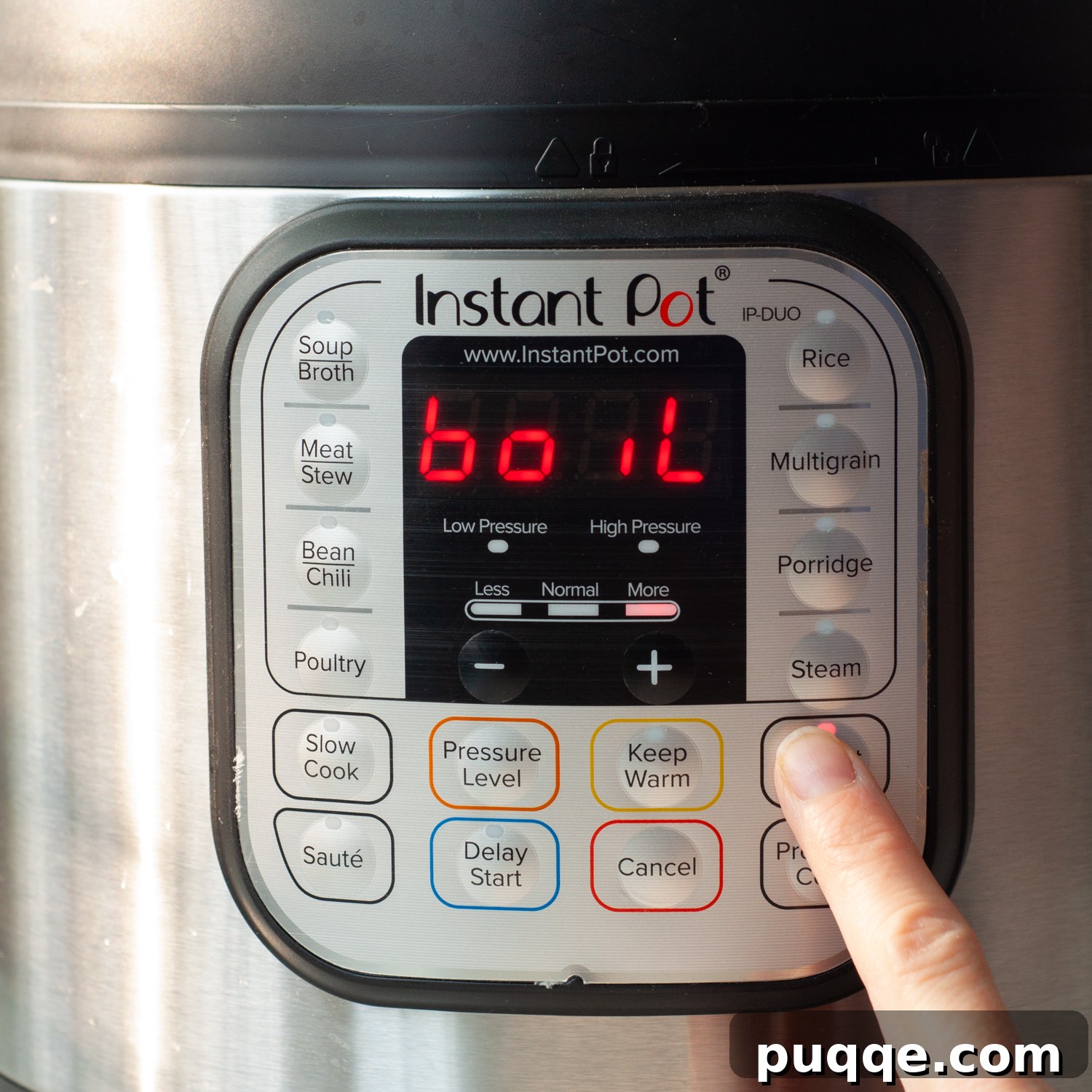 Finger pressing the 'Yogurt' button on an Instant Pot, with 'Boil' displayed on the screen.