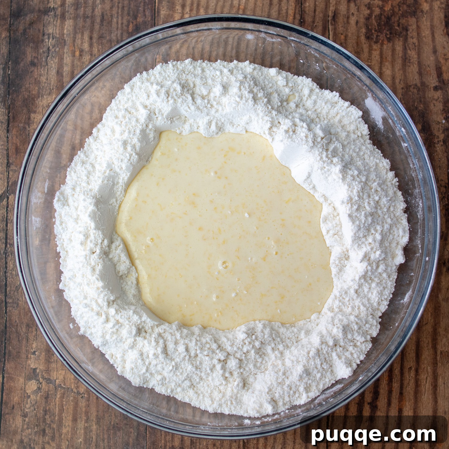 Melt-in-Your-Mouth Sweet Irish Soda Bread 4 Wet ingredients (melted butter, buttermilk, egg) being poured into the well of dry ingredients in a mixing bowl.