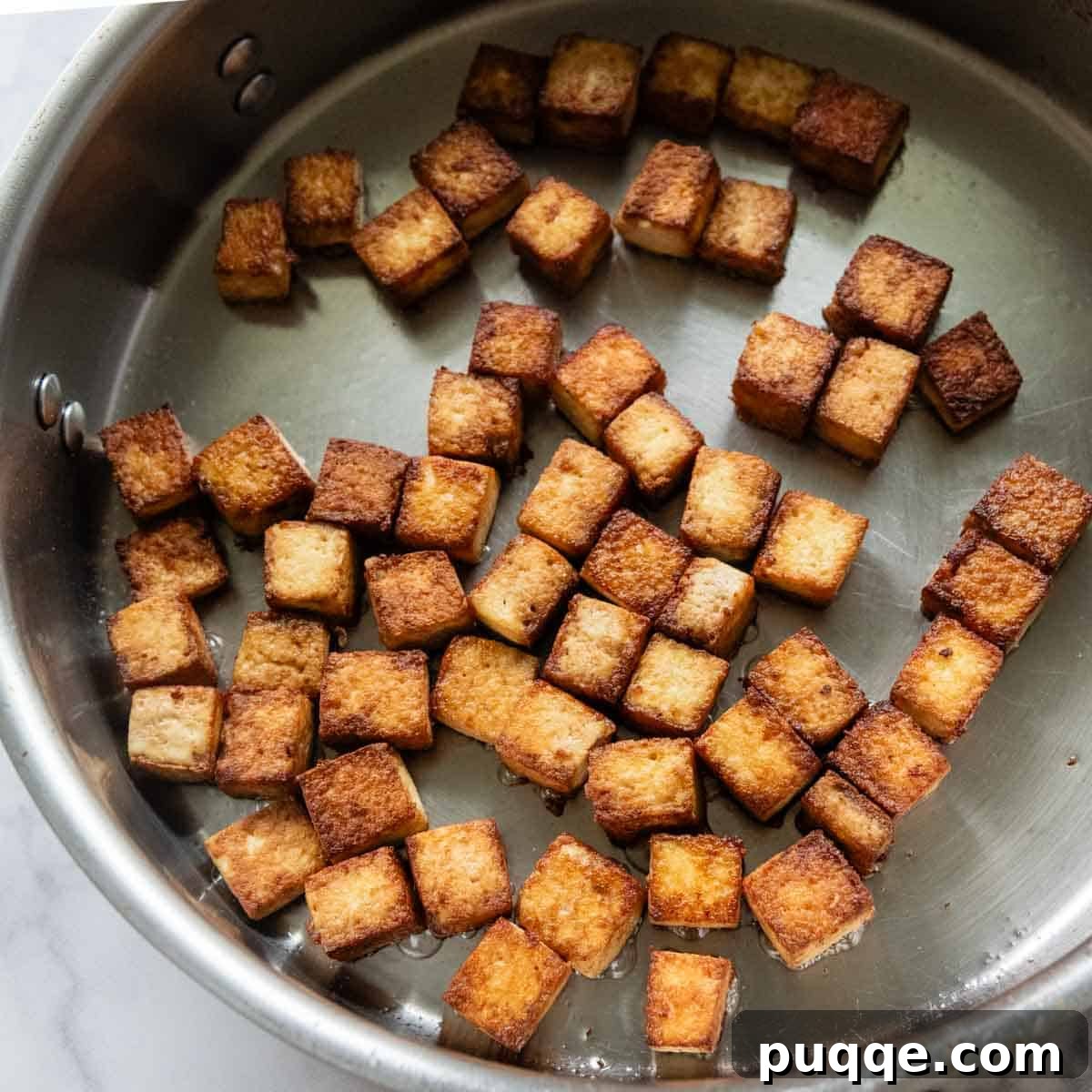 Pan-Frying Crispy Tofu crispy tofu in a frying pan.