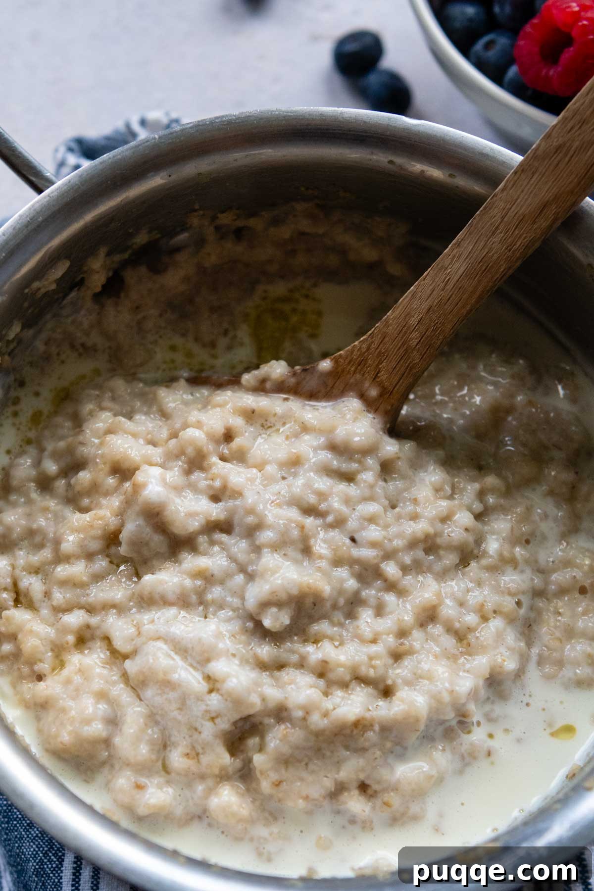 Velvety Maple Oat Bran Gluten-Free Morning Bliss 5 Gluten-free oat bran porridge ingredients mixed together and gently simmering in a saucepan on the stovetop.
