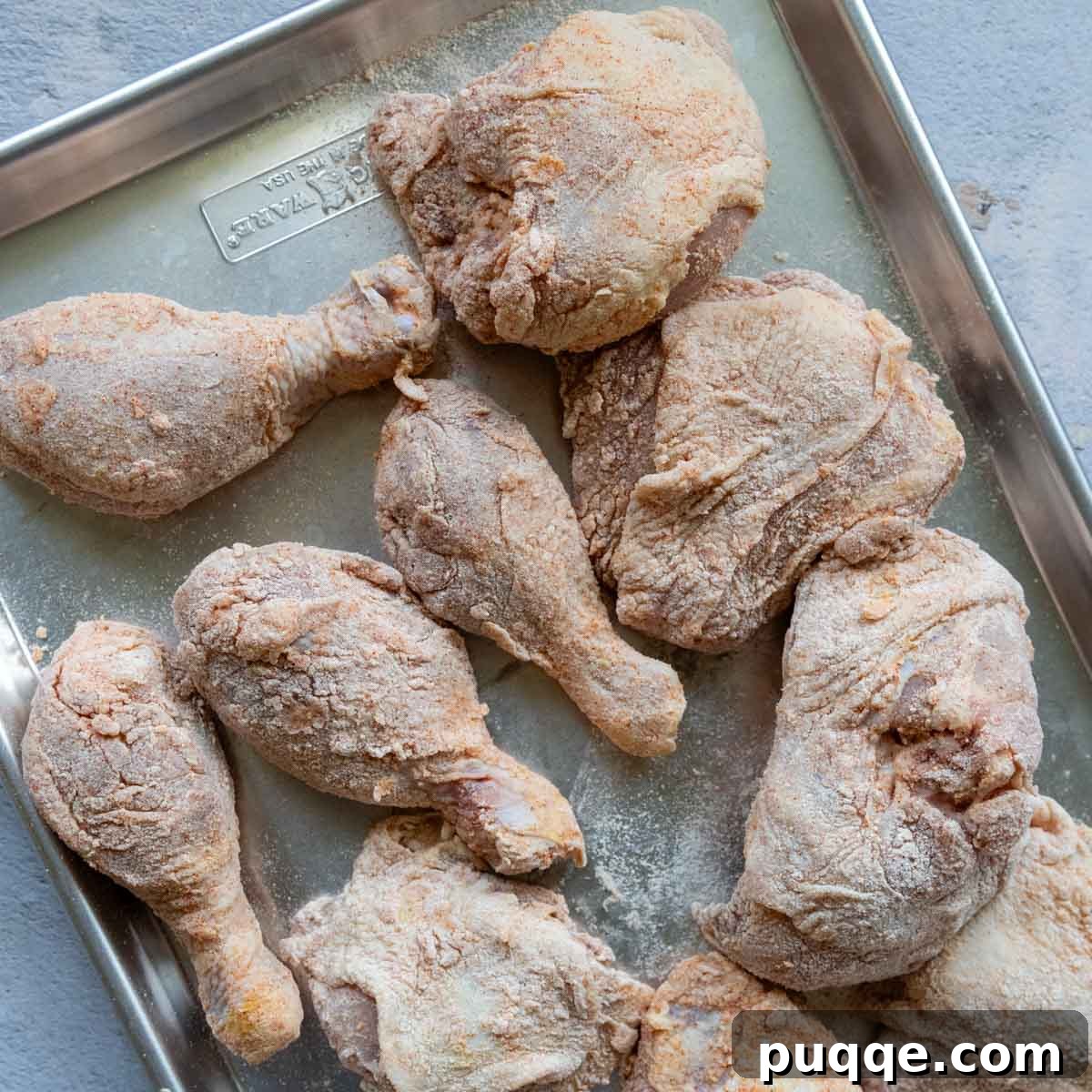 Crispy Gluten-Free Oven Fried Chicken 5 Unbaked, breaded chicken pieces meticulously arranged on a baking sheet, ready for the oven.