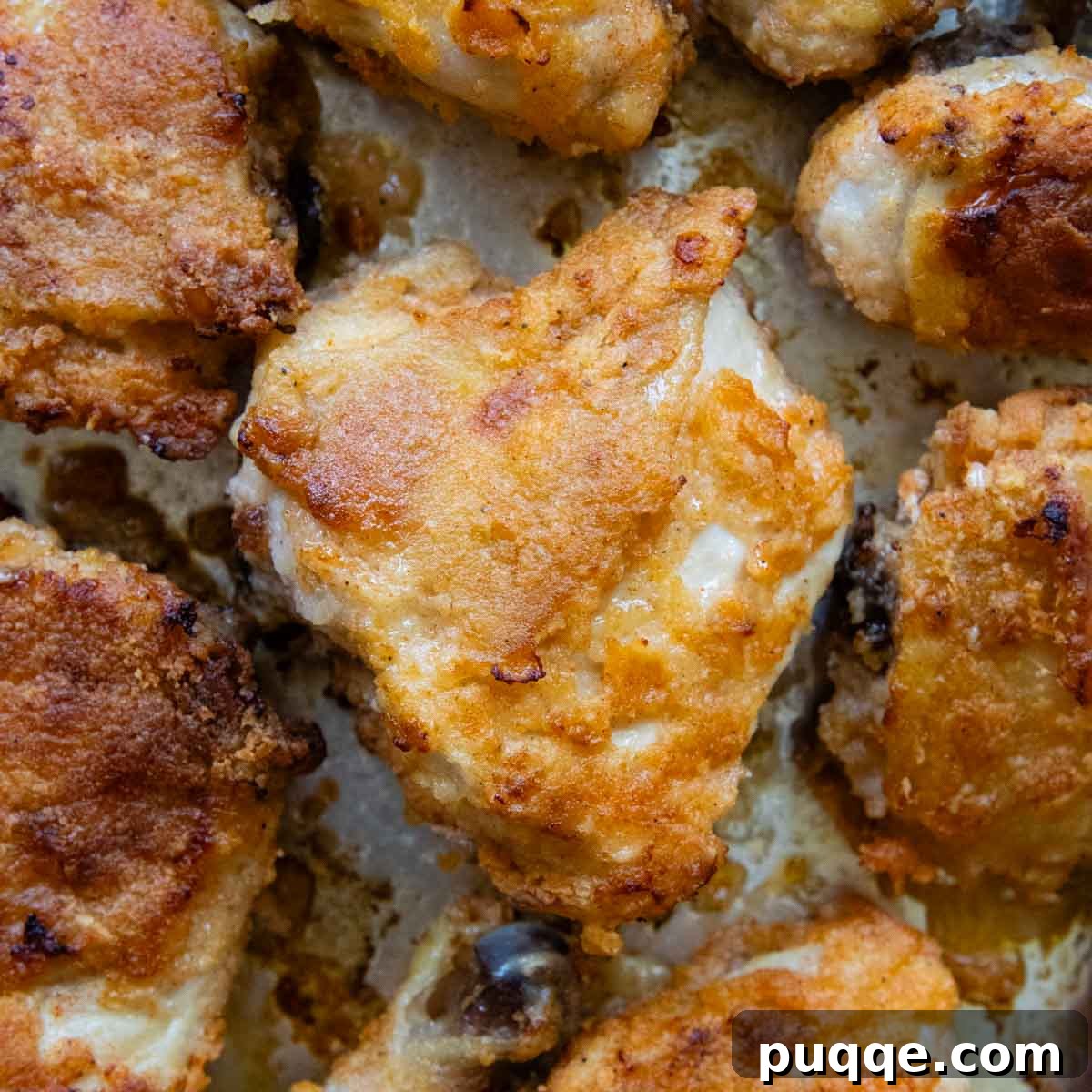 Crispy Gluten-Free Oven Fried Chicken 6 An overhead shot of perfectly oven-fried chicken, golden and crispy, on a baking sheet, surrounded by various side dishes.