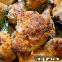 Crispy Gluten-Free Oven Fried Chicken 7 Close-up of golden brown gluten-free oven-fried chicken pieces on a baking sheet, showcasing their crispy skin.