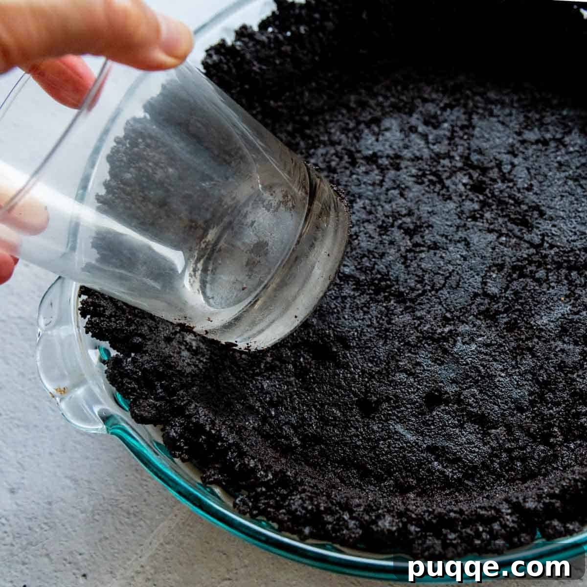 Easy Gluten-Free Oreo Crust for Perfect Slices 5 edges being shaped by a drinking glass.