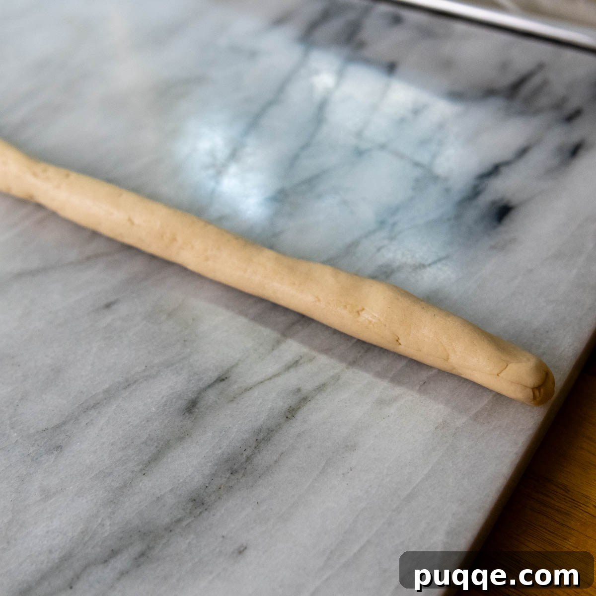 Pillowy Soft Gluten-Free Pretzels Simple Recipe 7 Gluten-free dough rolled into a long, uniform rope, ready for shaping.
