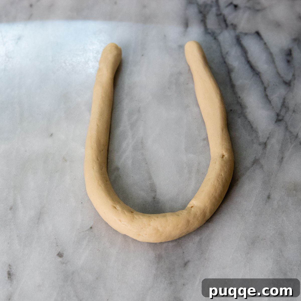 Pillowy Soft Gluten-Free Pretzels Simple Recipe 8 The dough rope shaped into a horseshoe, the initial step before twisting.