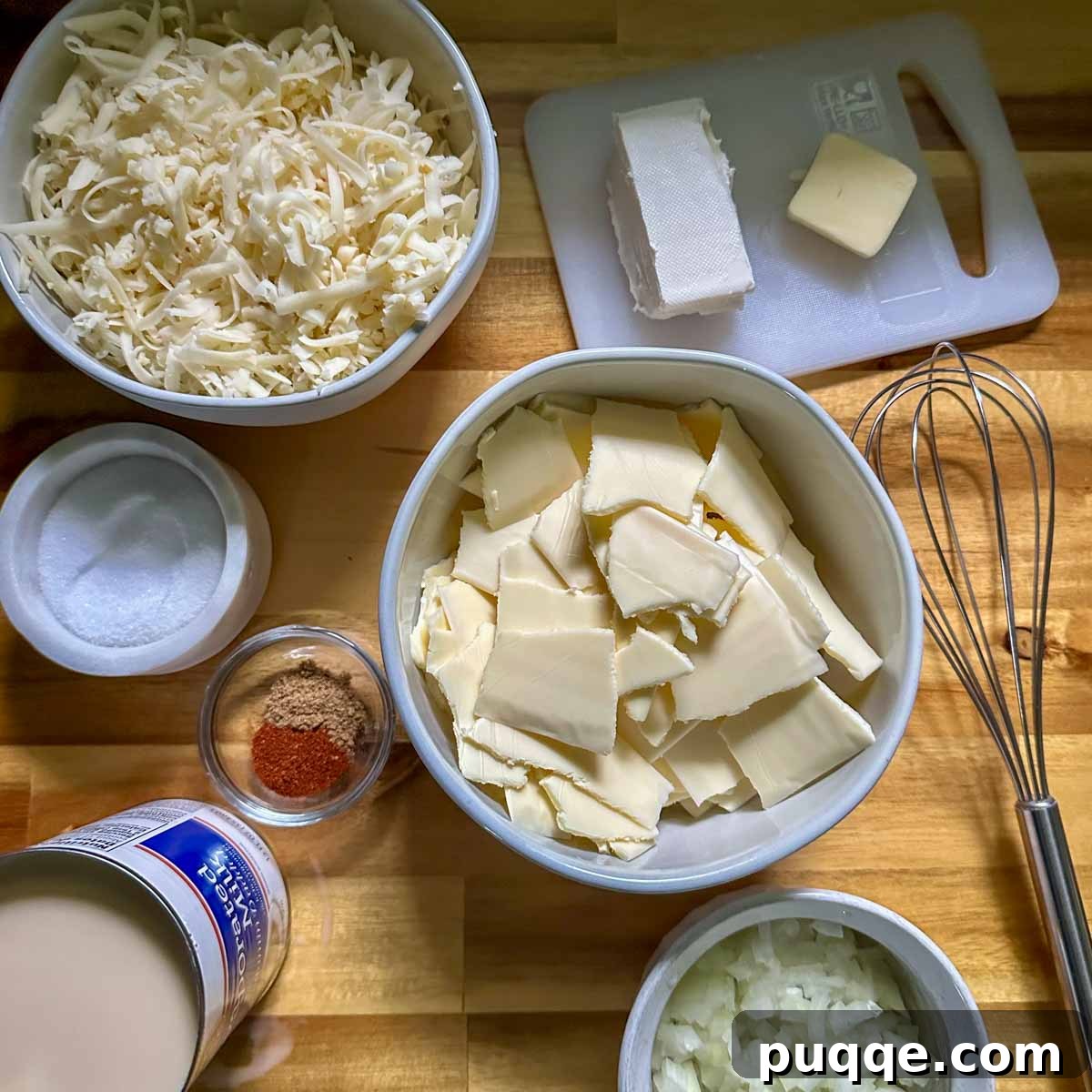 All cheese sauce ingredients, including grated cheese, diced onion, and spices, are prepped and neatly arranged in small bowls.