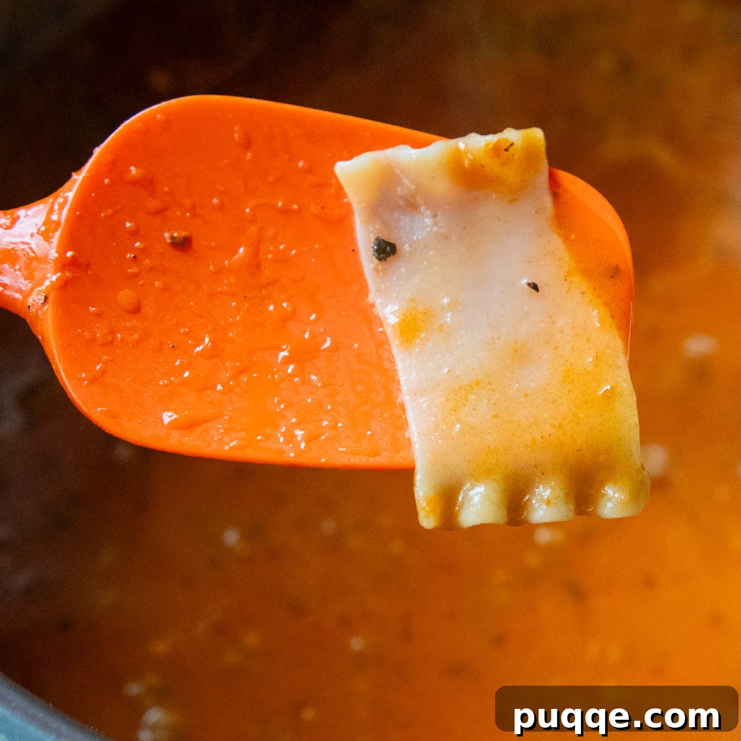 Ultimate 30-Minute Gluten-Free Lasagna Soup 4 An orange spoon gently lifts a gluten-free lasagna noodle from the simmering soup, checking for perfect doneness.