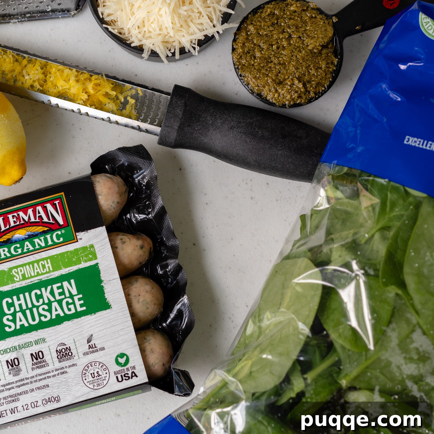 Ingredients for chicken sausage pasta laid out, showcasing fresh spinach, sausage, pasta, and sauce components.